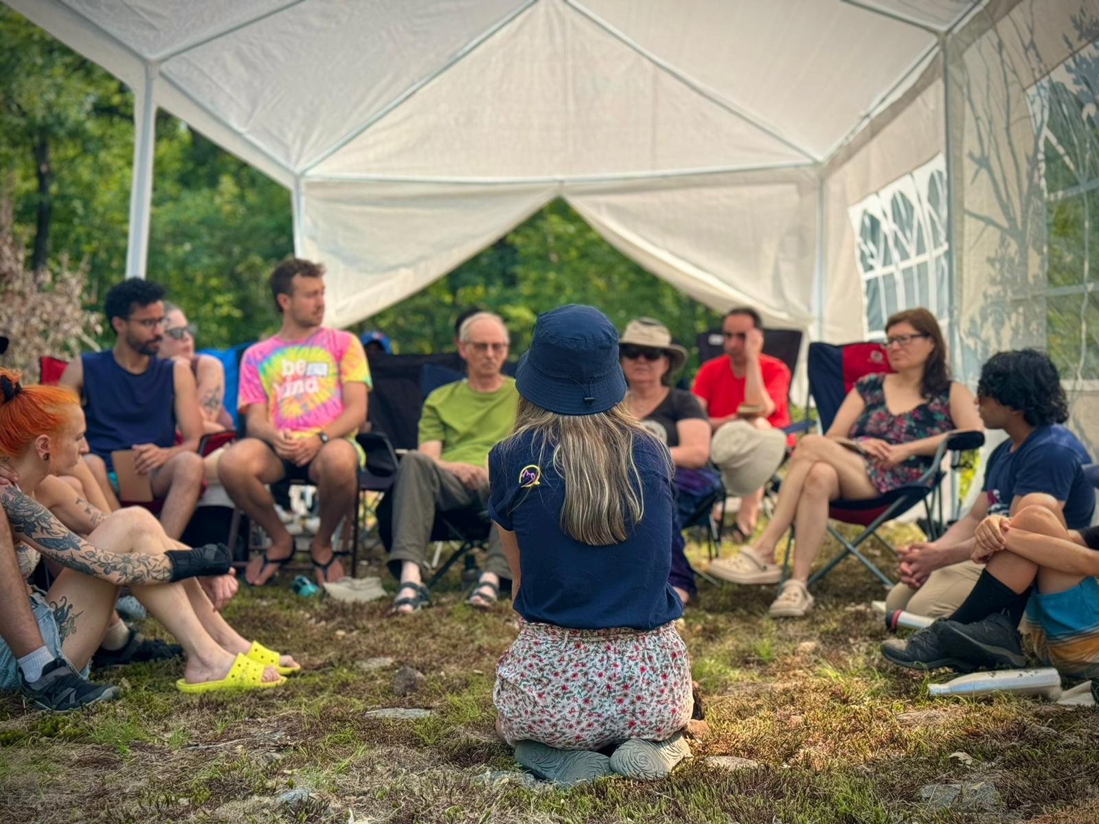 WTF volunteers sitting together under a tent at an activist camp