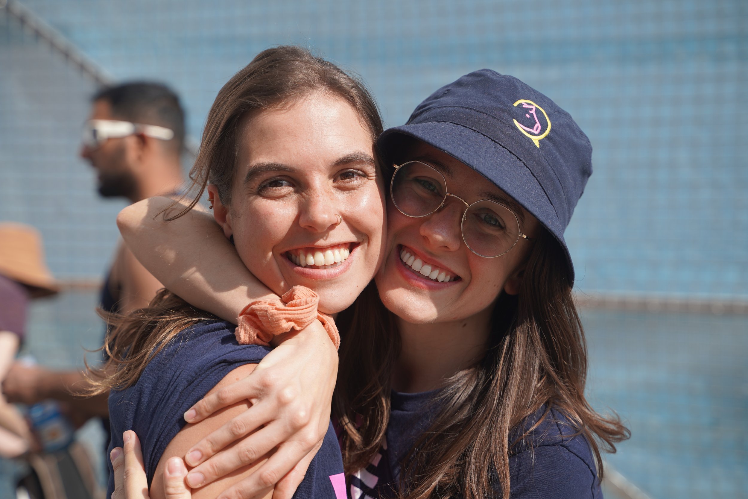 Two WTF volunteers hugging and laughing at an outdoor event